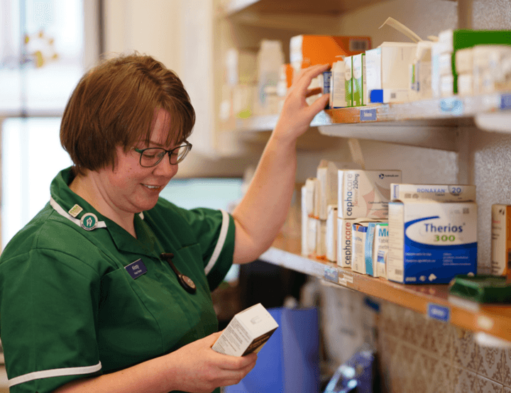 A veterinary nurse reaching for medication