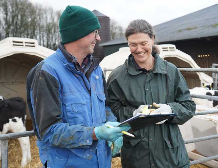 Vet Sabine Boye laughing with a dairy farmer